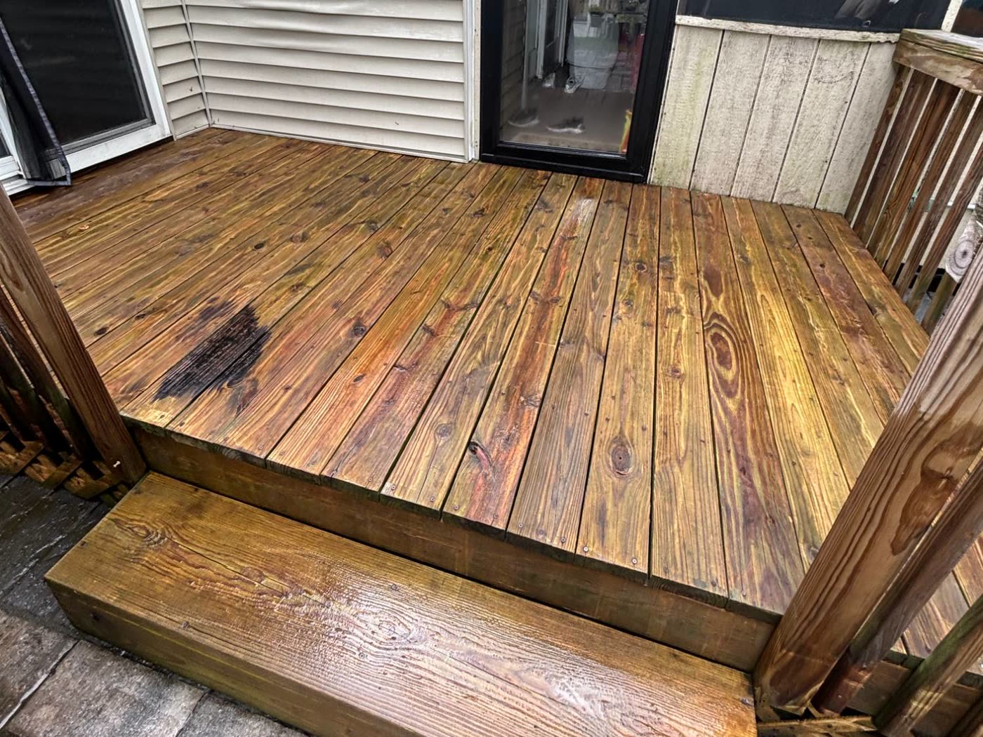 The same deck after washing — warm brown timber, grain showing again