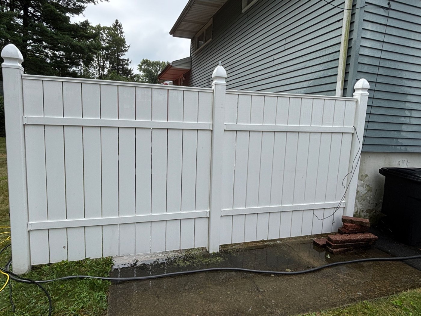 The same fence after washing — bright white again