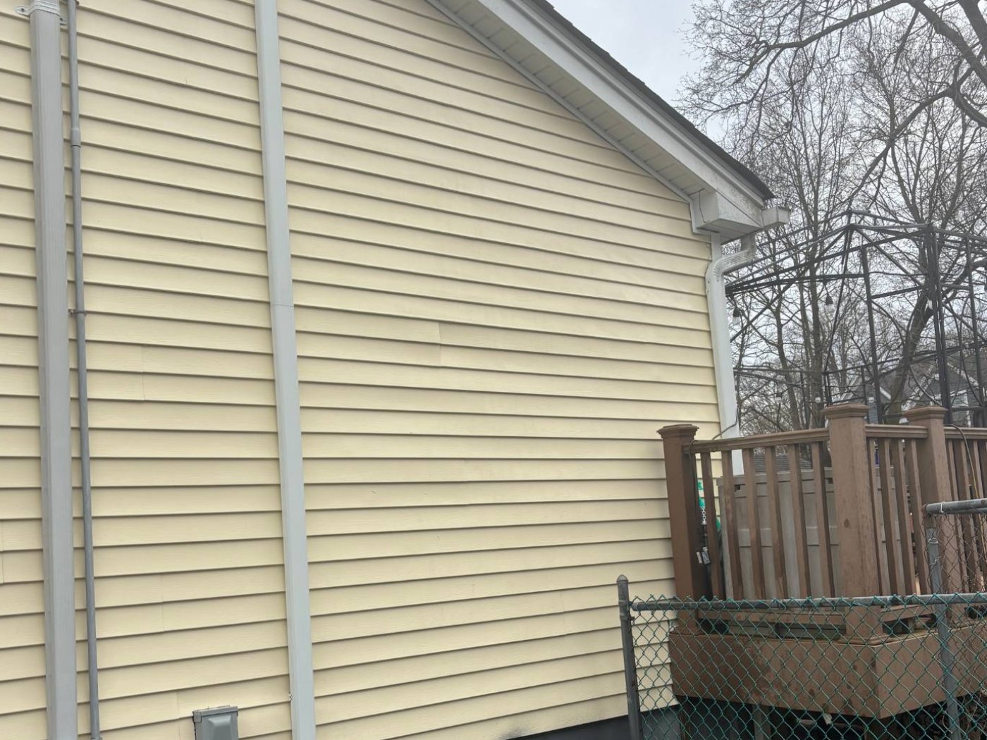 The same yellow siding after washing — bright and evenly colored